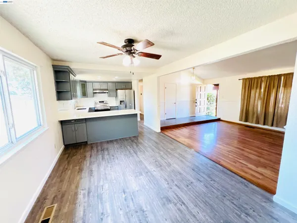a living room with stainless steel appliances kitchen island hardwood floor and wooden floors