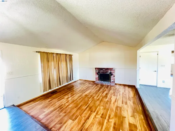 a view of a bedroom with wooden floor and a cabinet