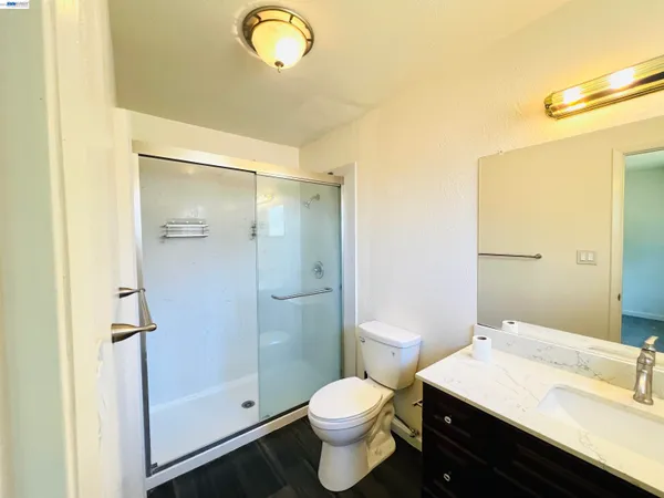 a bathroom with a sink a toilet a shower and a mirror