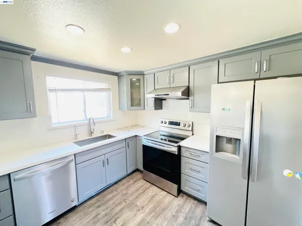 a kitchen with stainless steel appliances granite countertop a refrigerator stove and sink