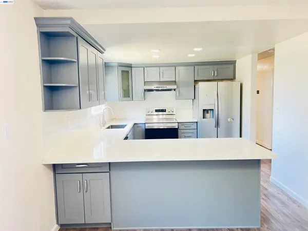 a kitchen with kitchen island a refrigerator and a sink