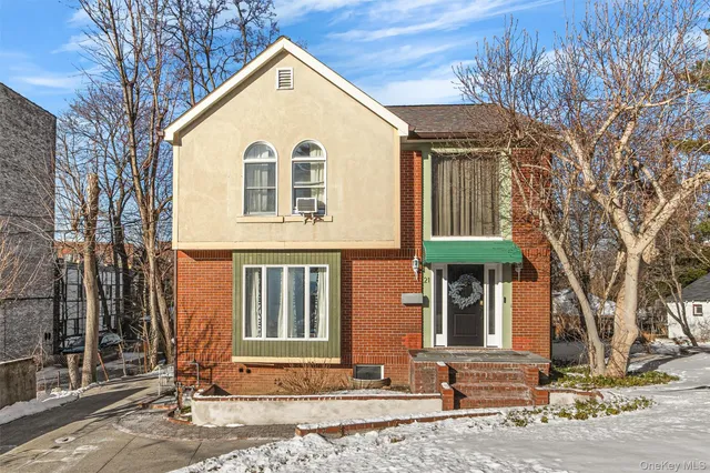 a view of a white house with a large tree