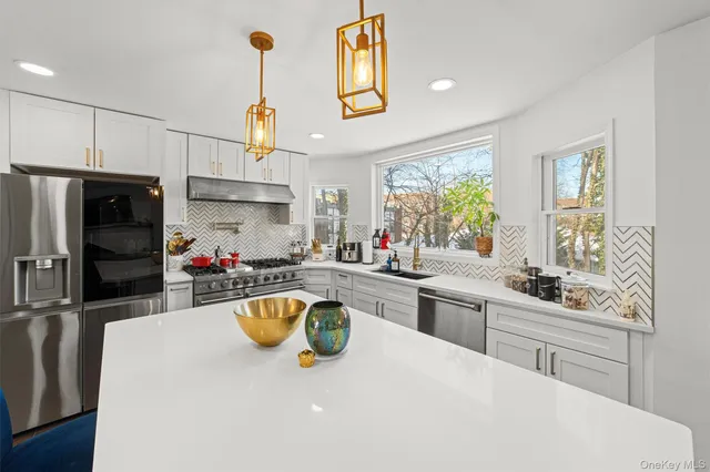 a kitchen that has a lot of cabinets a sink and appliances