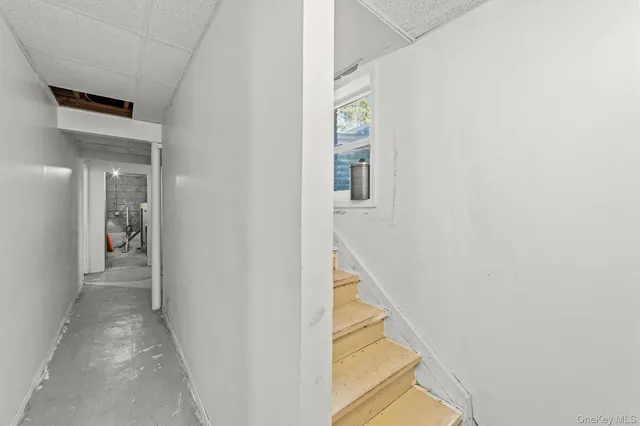a view of a hallway with a white walls and stairs