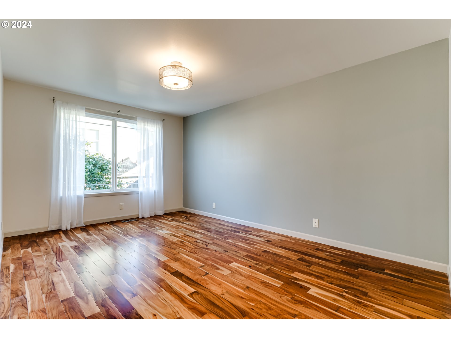 686 South 69th Place Springfield, OR 97478 - Photo 16 of 38 a view of an empty room with wooden floor and a window