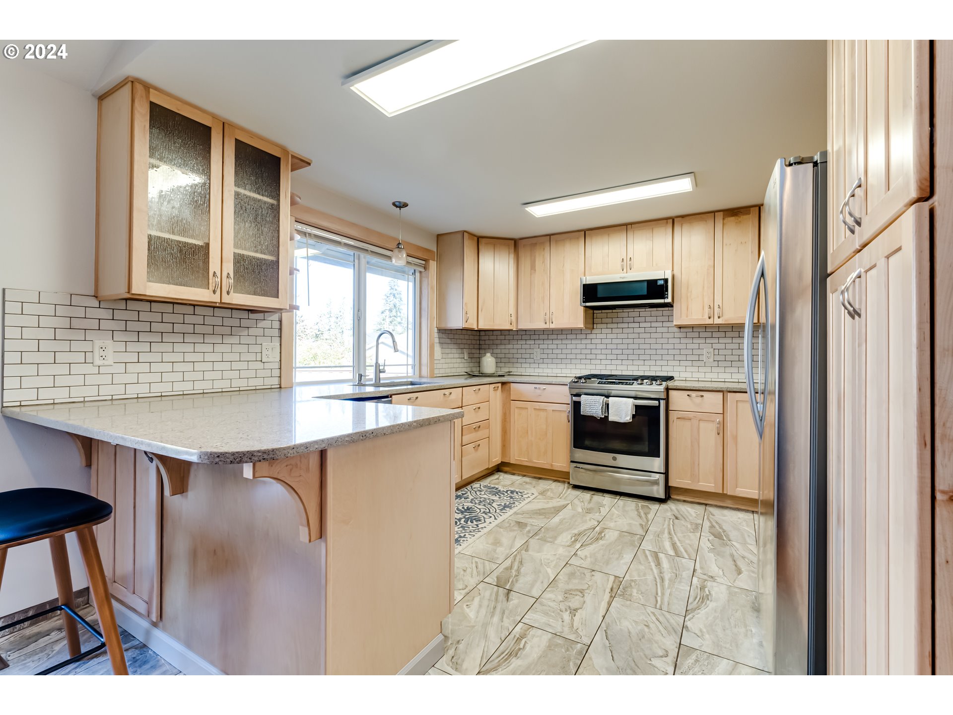 686 South 69th Place Springfield, OR 97478 - Photo 9 of 38 a kitchen with kitchen island a counter top space a sink stainless steel appliances and cabinets