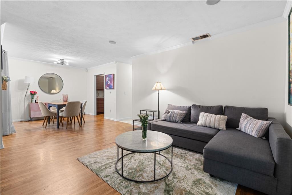 a living room with furniture and a wooden floor