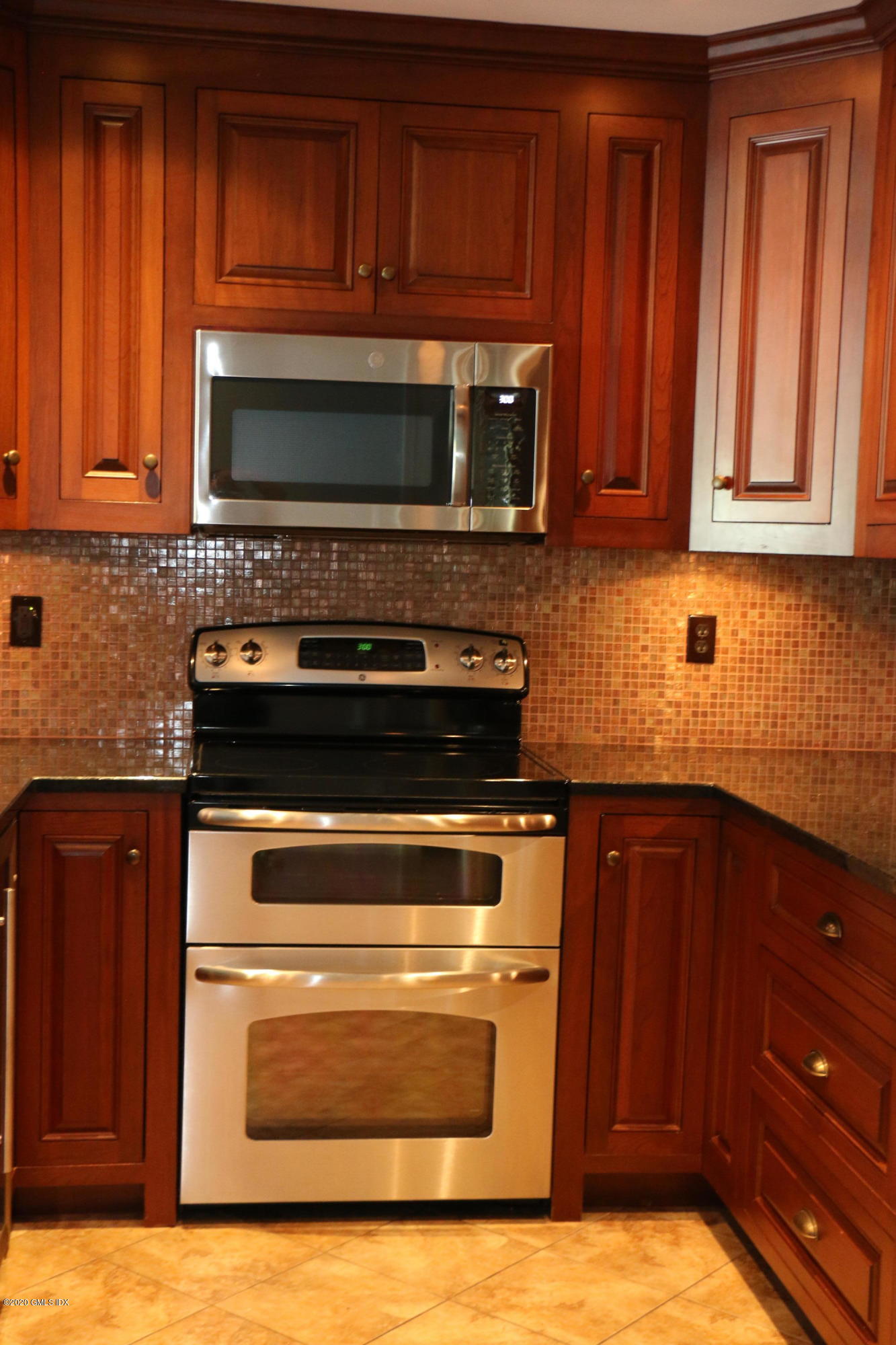 11 River Road, Unit 114 Cos Cob, CT 06807 - Photo 7 of 21 a kitchen with wooden cabinets and a stove top oven