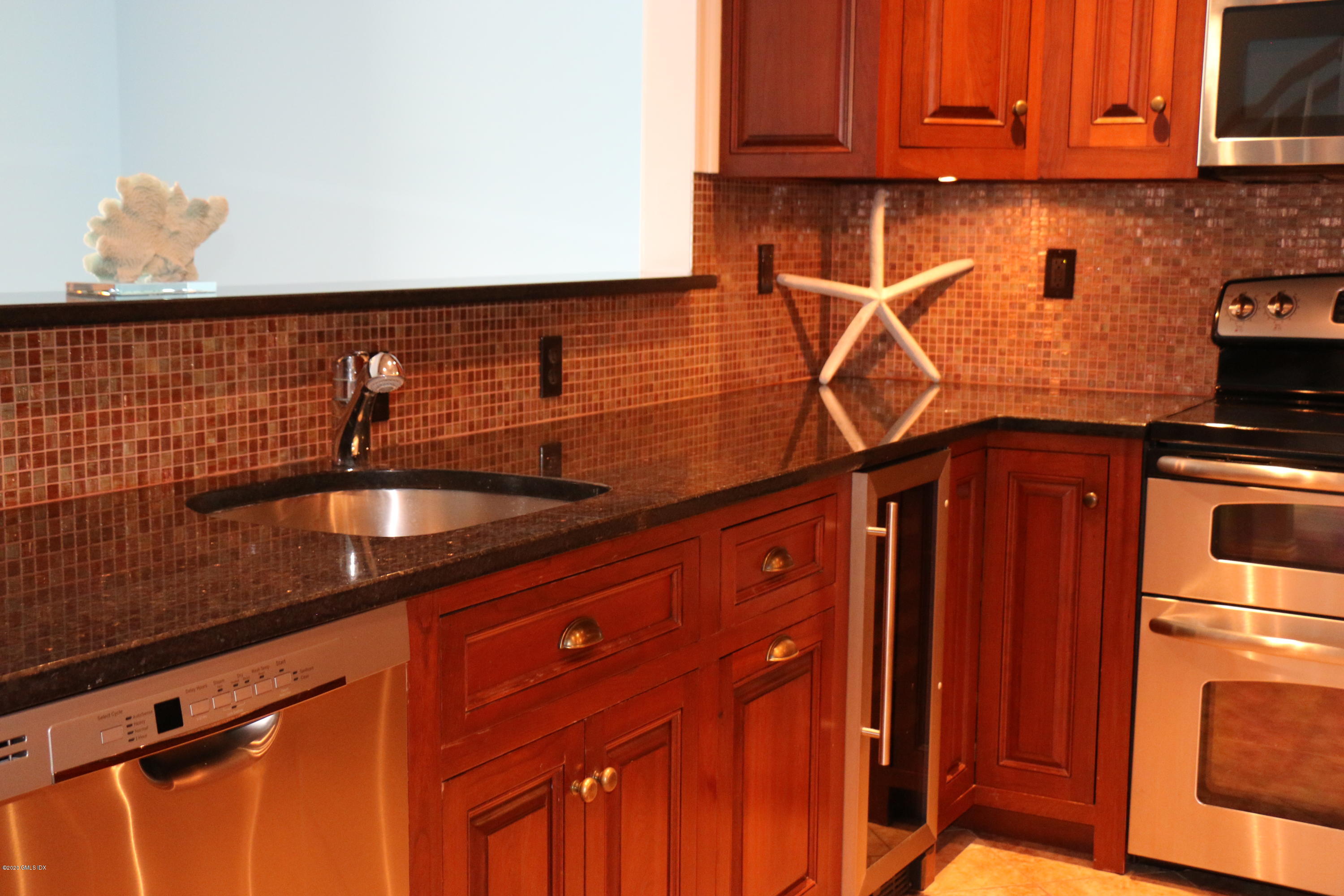 11 River Road, Unit 114 Cos Cob, CT 06807 - Photo 8 of 21 a kitchen with stainless steel appliances granite countertop a sink and cabinets