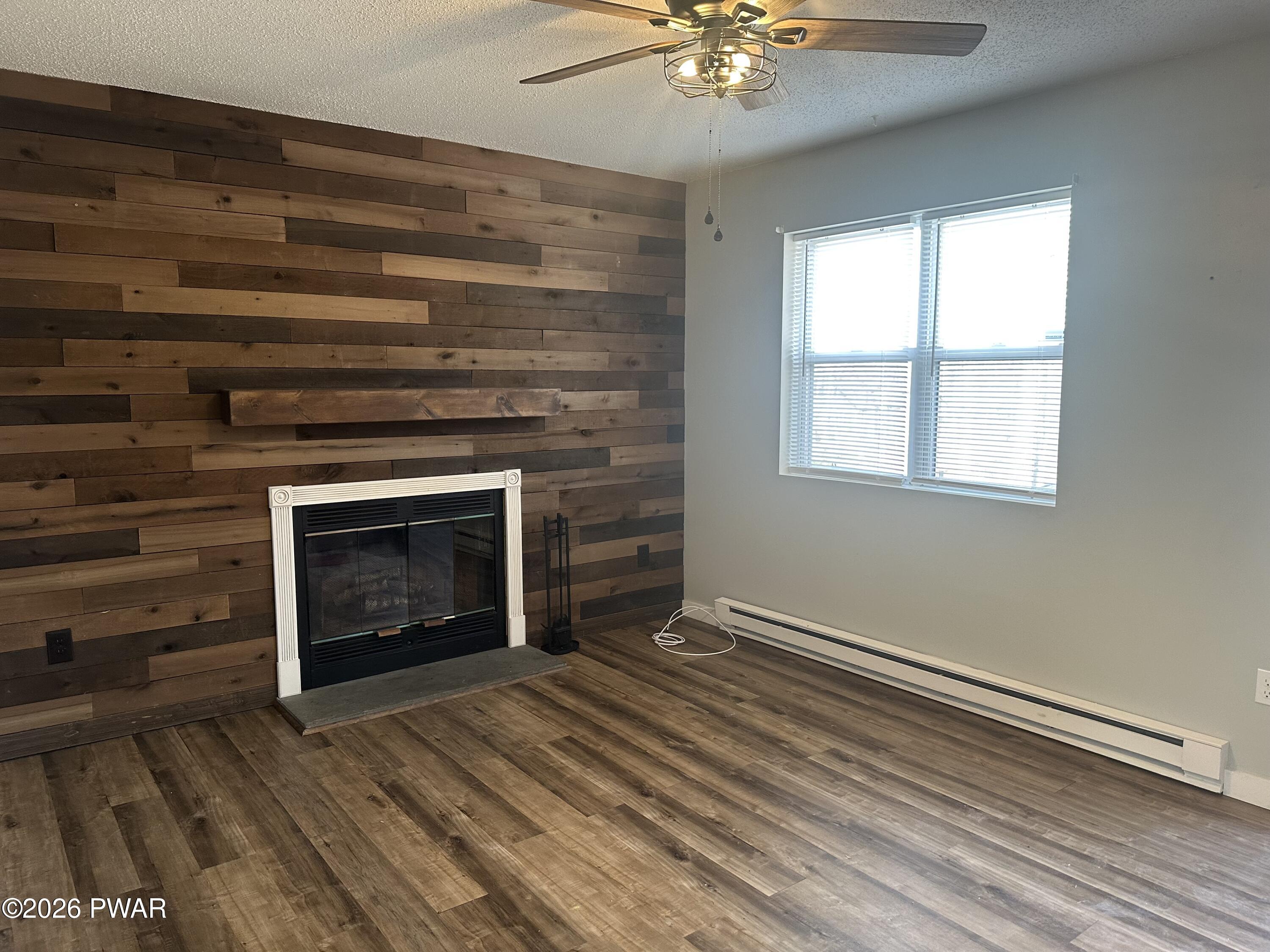 2116 Spring Drive Bushkill, PA 18324 - Photo 2 of 19 wooden floor fireplace and windows in an empty room