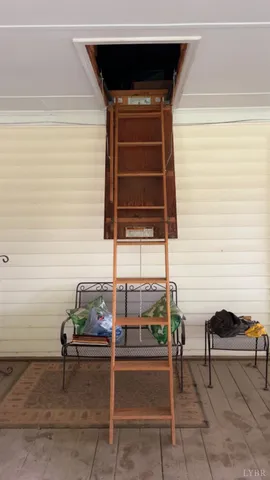 a living room with a chair and a potted plant on the wall