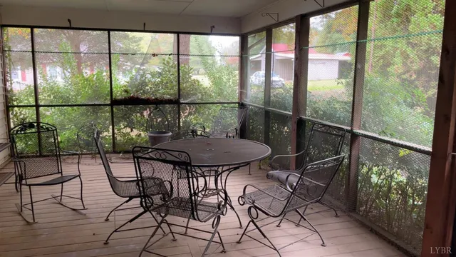 a view of a balcony with chairs and wooden floor
