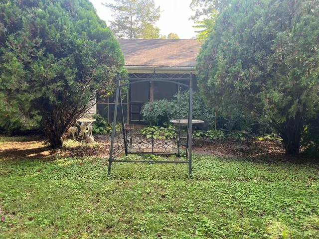 a view of house with a backyard