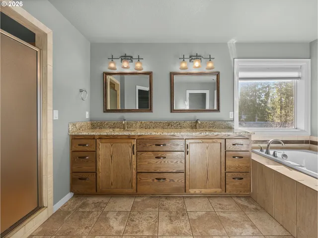 a spacious bathroom with a tub sink and mirror