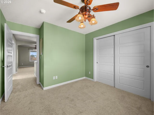 an empty room with a window and ceiling fan