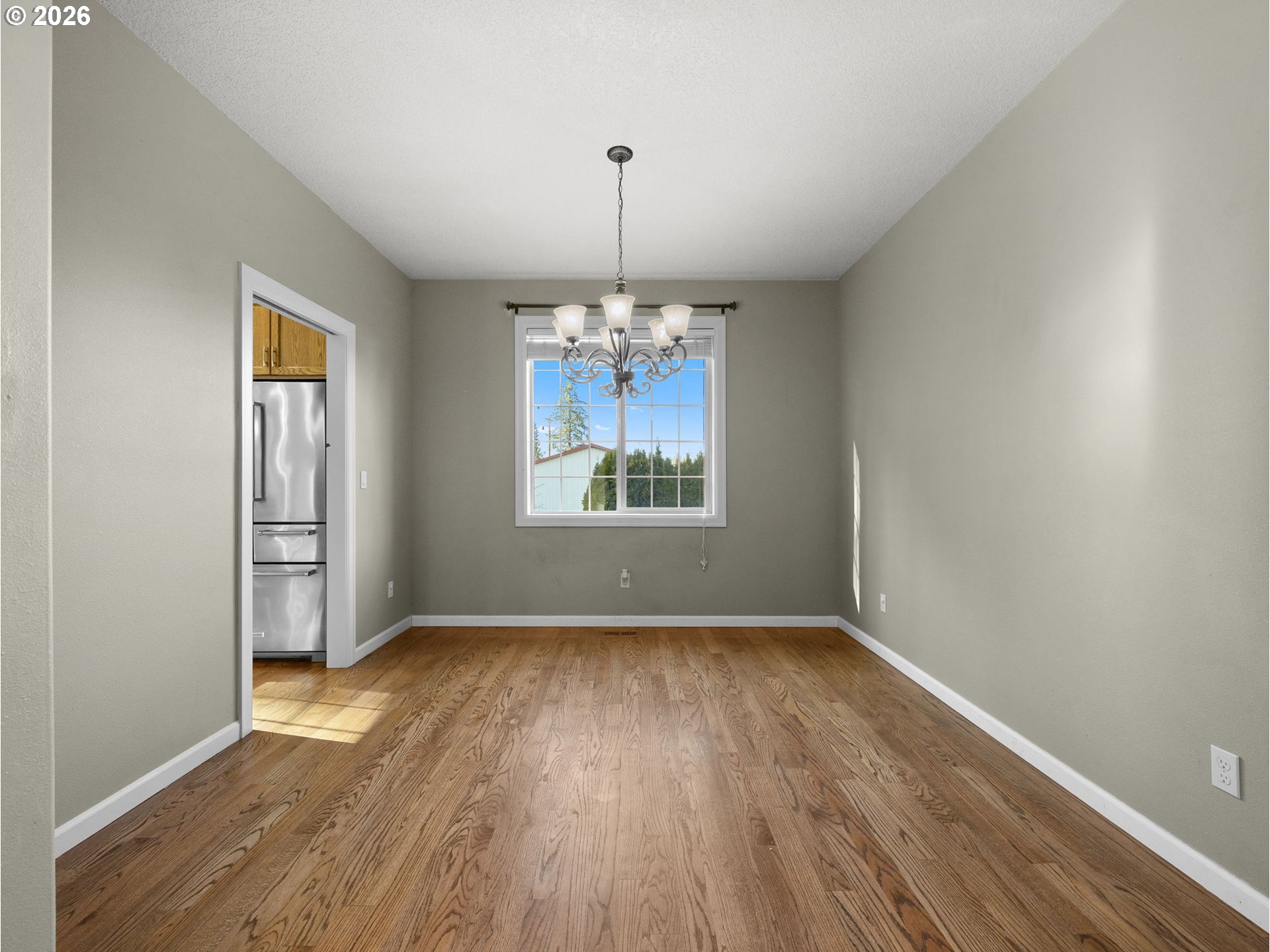 40192 Laurel Street Sandy, OR 97055 - Photo 4 of 37 an empty room with wooden floor chandelier and windows