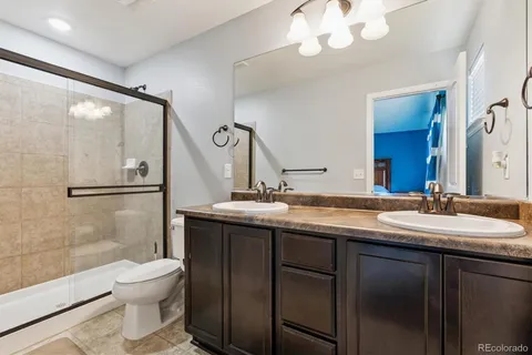 a bathroom with a granite countertop sink a toilet and a mirror