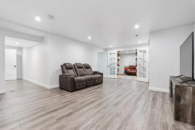 a living room with furniture and a wooden floor
