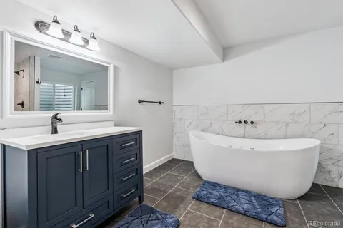 a spacious bathroom with a double vanity sink mirror and bathtub