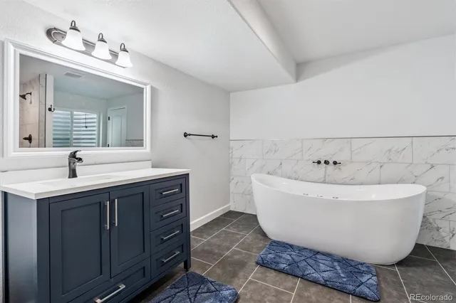 a spacious bathroom with a double vanity sink mirror and bathtub