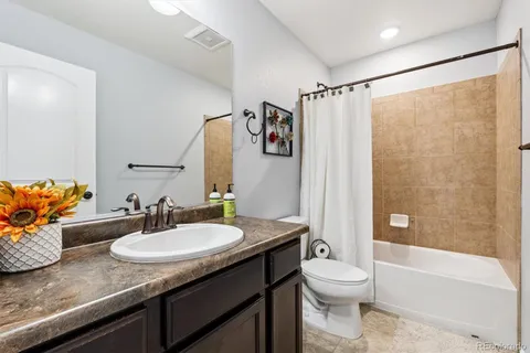a bathroom with a granite countertop sink toilet and shower