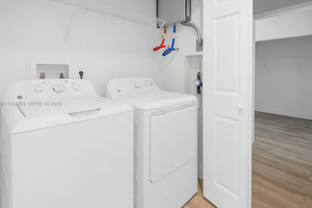 an empty room with wooden floor closet and windows