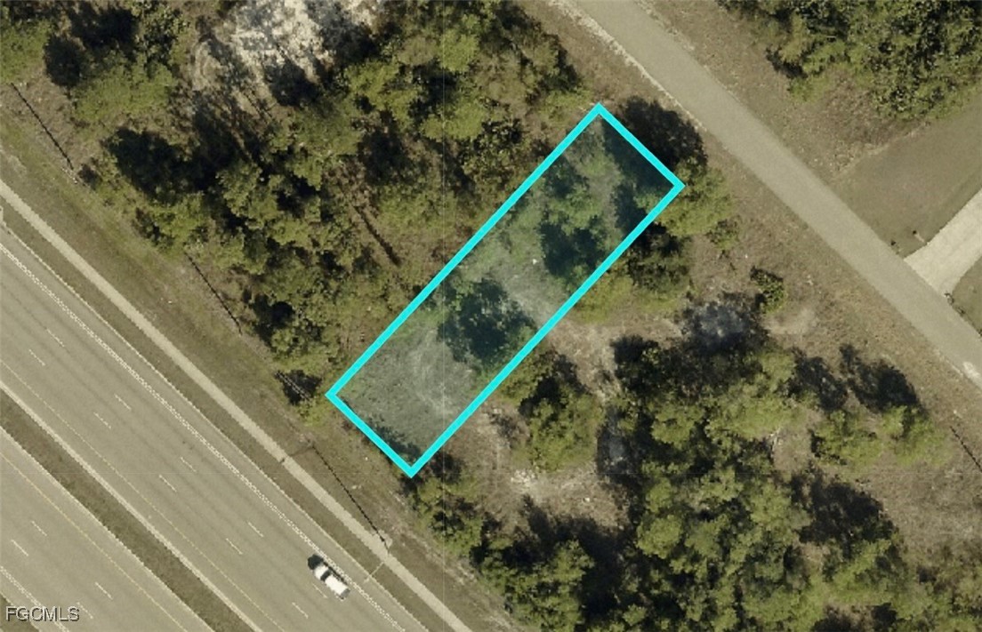 188 Meadow Road Lehigh Acres, FL 33973 - Photo 2 of 5 a green field with lots of trees
