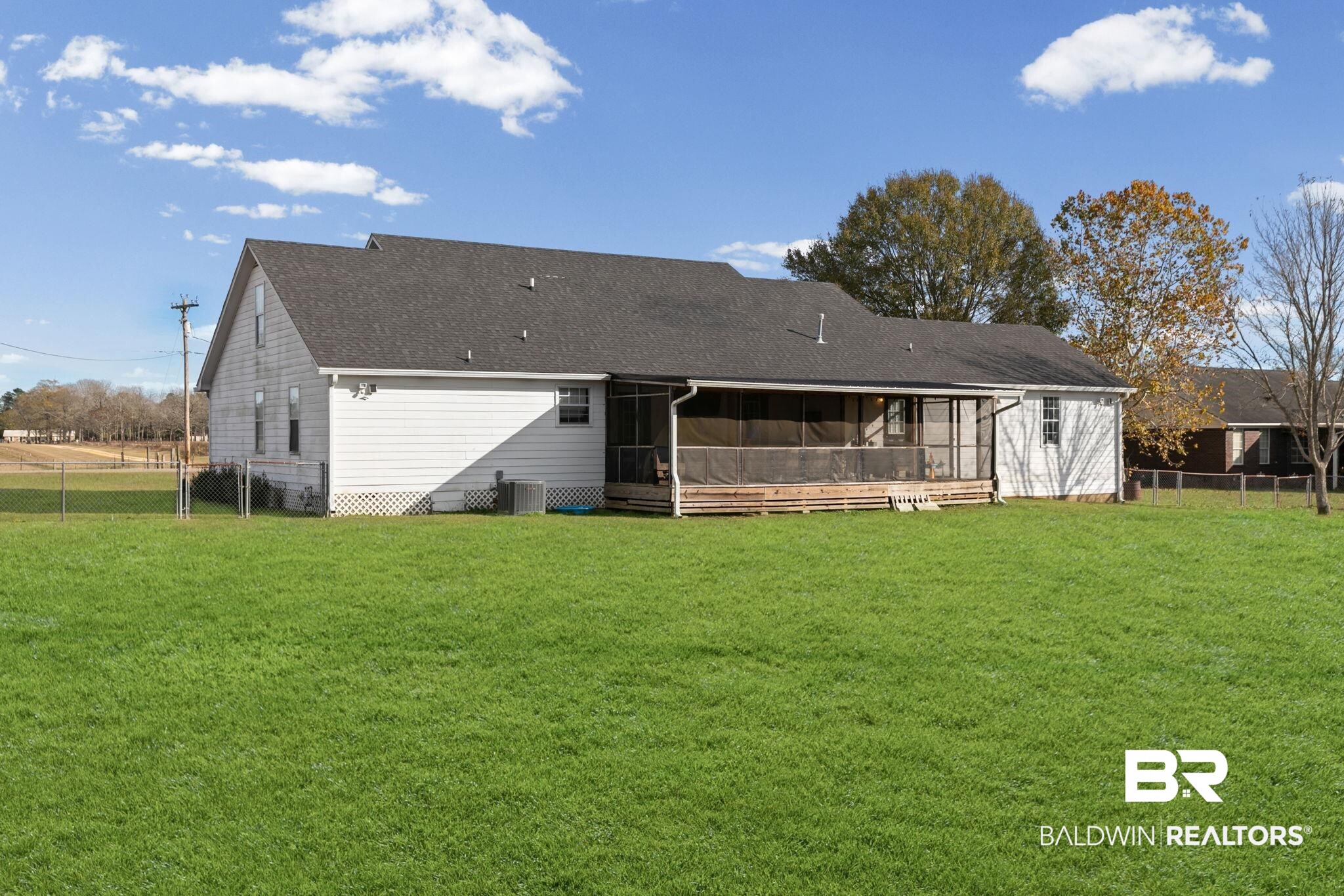 3842 Experiment Farm Road Monroeville, AL 36460 - Photo 11 of 59 Back of house featuring a fenced backyard, roof with shingles, and a sunroom