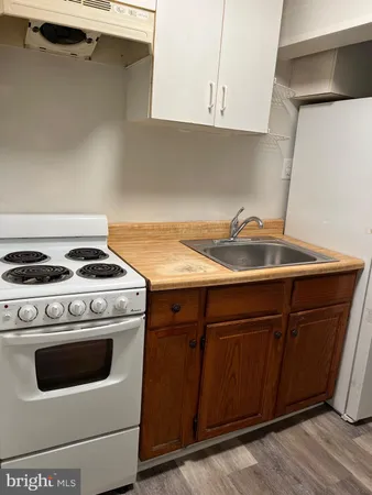 a kitchen with granite countertop a sink stove and cabinets