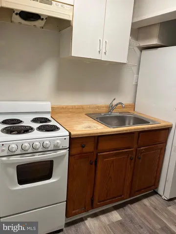 a kitchen with granite countertop a sink stove and cabinets
