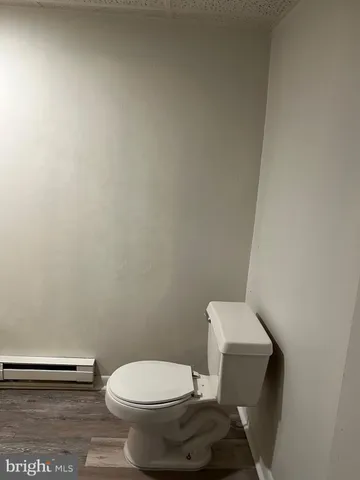 a white toilet sitting next to a white wall