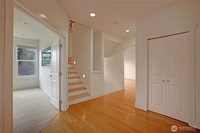 a view of a hallway with wooden floor and entryway