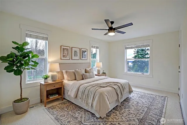a bedroom with a large bed and a potted plant