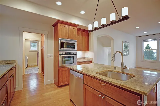 a kitchen with stainless steel appliances granite countertop a sink a stove and a refrigerator