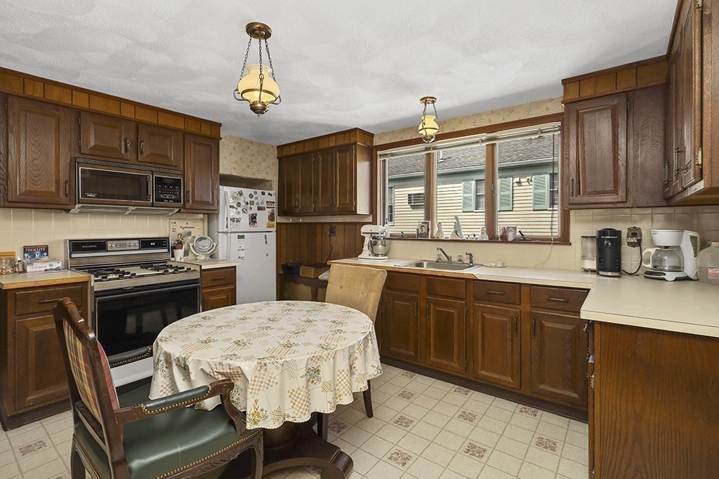 61 Everett Street Everett, MA 02149 - Photo 13 of 19 a kitchen with a sink a microwave and wooden cabinets