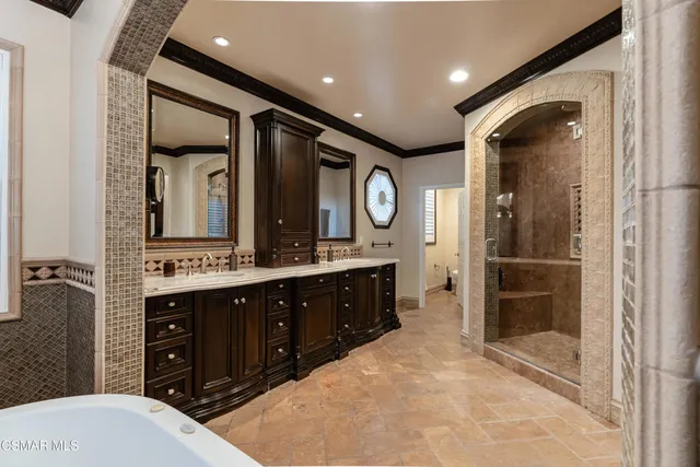 a bathroom with a tub a sink and a large mirror