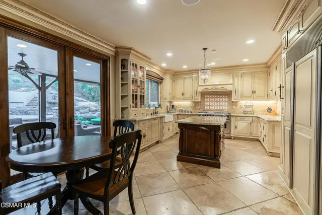 a kitchen with a table chairs refrigerator and cabinets