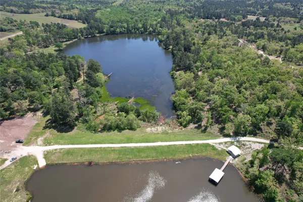 an aerial view of a house with a yard and lake view