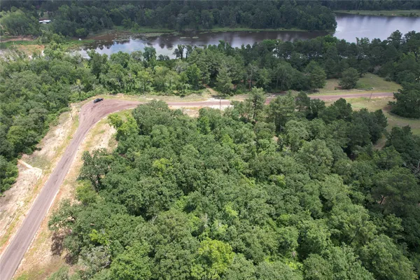 an aerial view of residential house with outdoor space and trees all around