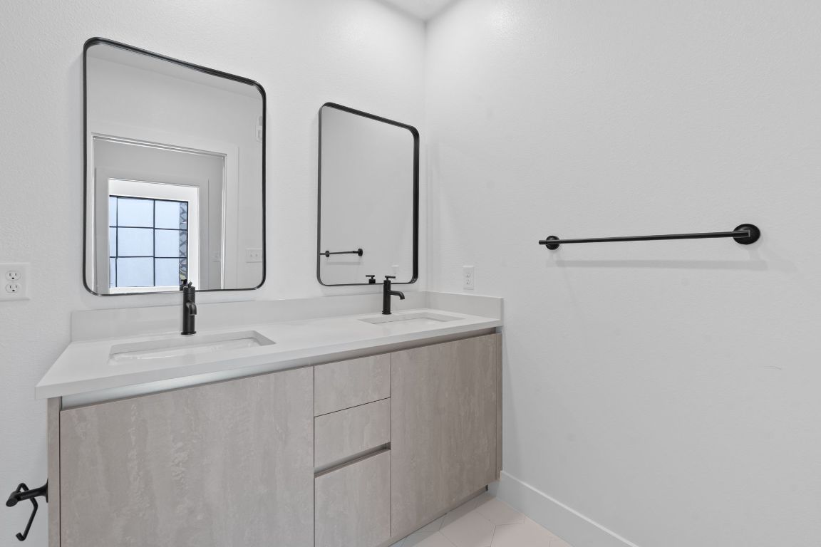 4315 South Congress Avenue, Unit 313 Austin, TX 78745 - Photo 12 of 38 a bathroom with a double vanity sink and a mirror