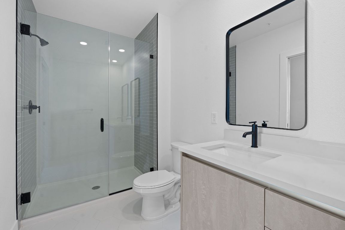 4315 South Congress Avenue, Unit 313 Austin, TX 78745 - Photo 13 of 38 a bathroom with a sink a toilet and shower