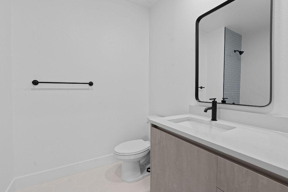 4315 South Congress Avenue, Unit 313 Austin, TX 78745 - Photo 15 of 38 a bathroom with a sink a toilet and mirror