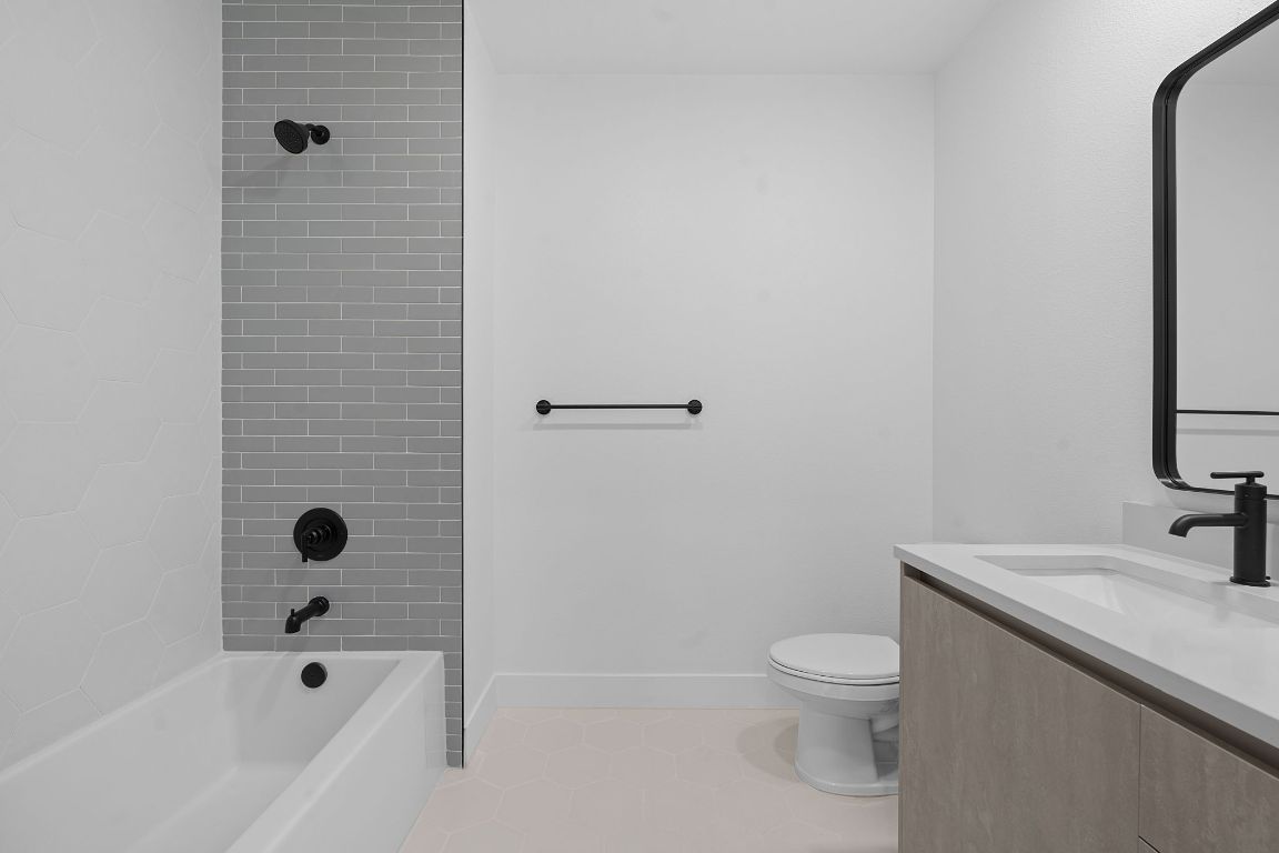 4315 South Congress Avenue, Unit 313 Austin, TX 78745 - Photo 16 of 38 a bathroom with a bathtub shower sink vanity and toilet