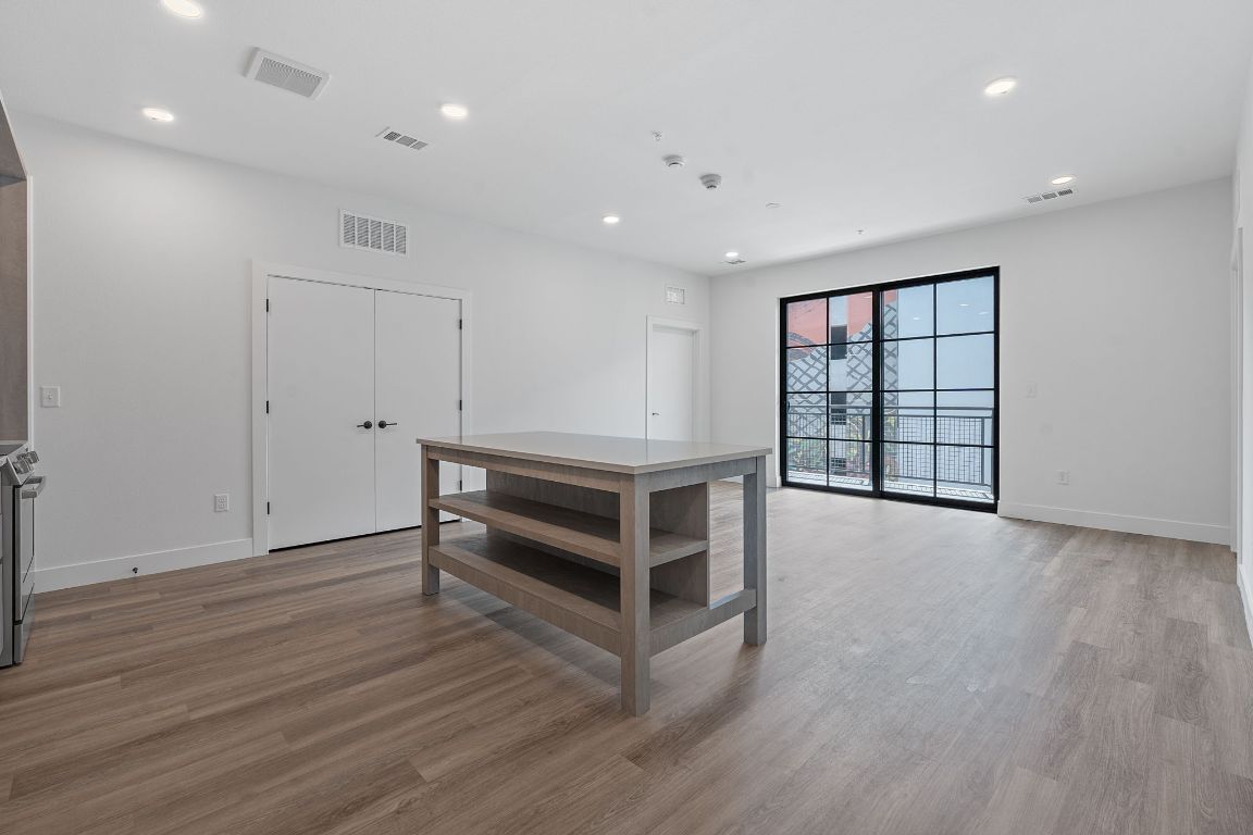 4315 South Congress Avenue, Unit 313 Austin, TX 78745 - Photo 2 of 38 a view of an empty room with wooden floor and a window