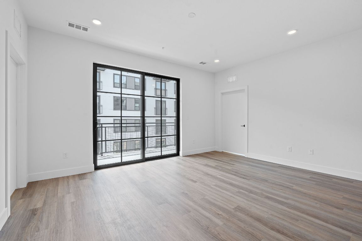 4315 South Congress Avenue, Unit 313 Austin, TX 78745 - Photo 3 of 38 a view of an empty room with wooden floor and a window