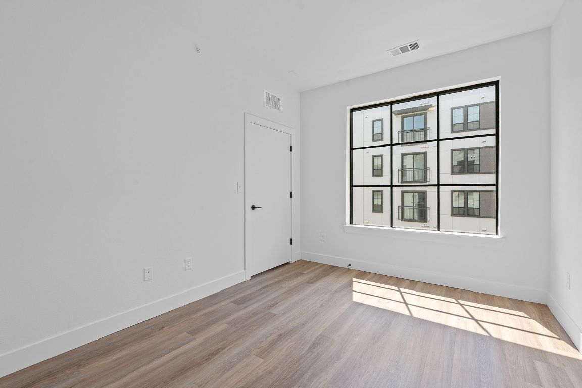 4315 South Congress Avenue, Unit 313 Austin, TX 78745 - Photo 6 of 38 a view of an empty room with a window and wooden floor