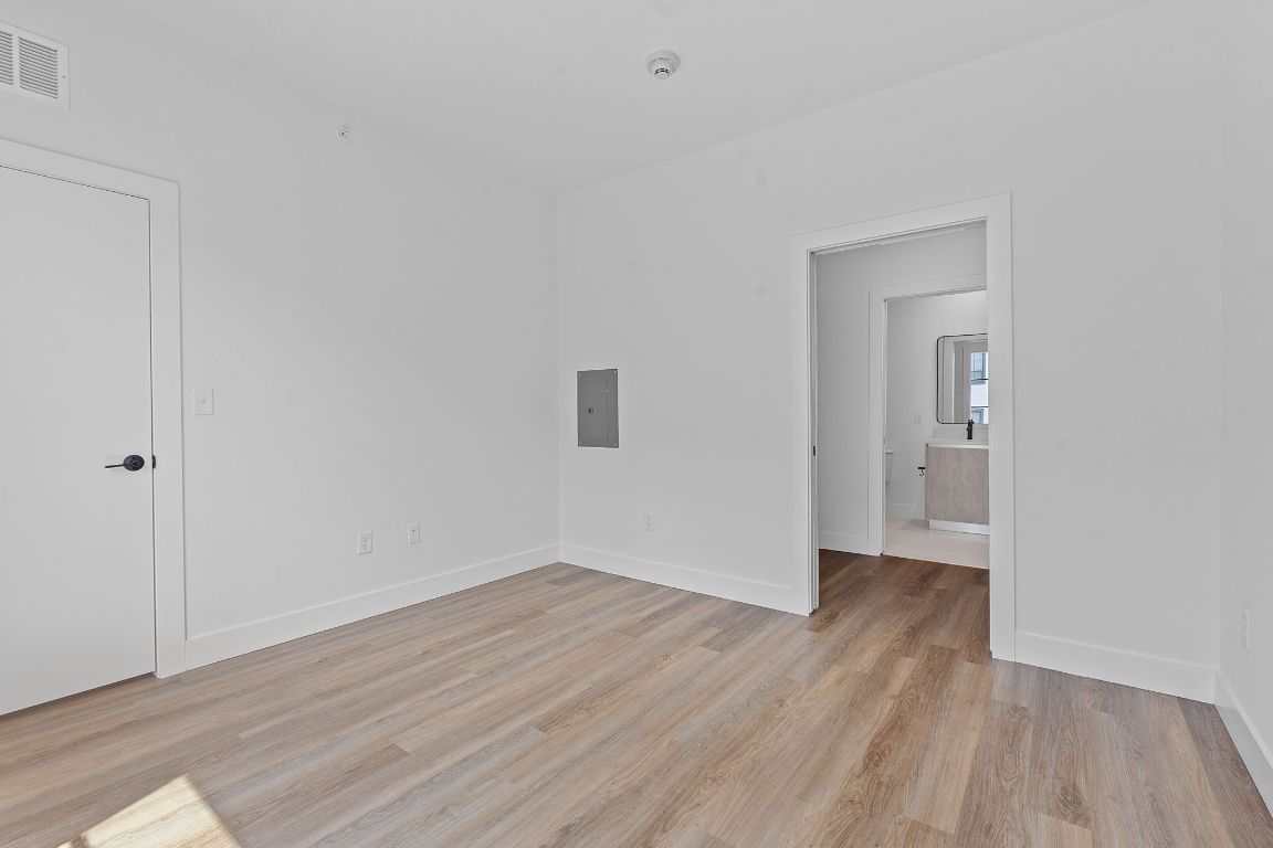 4315 South Congress Avenue, Unit 313 Austin, TX 78745 - Photo 10 of 38 a view of an empty room with wooden floor and a window