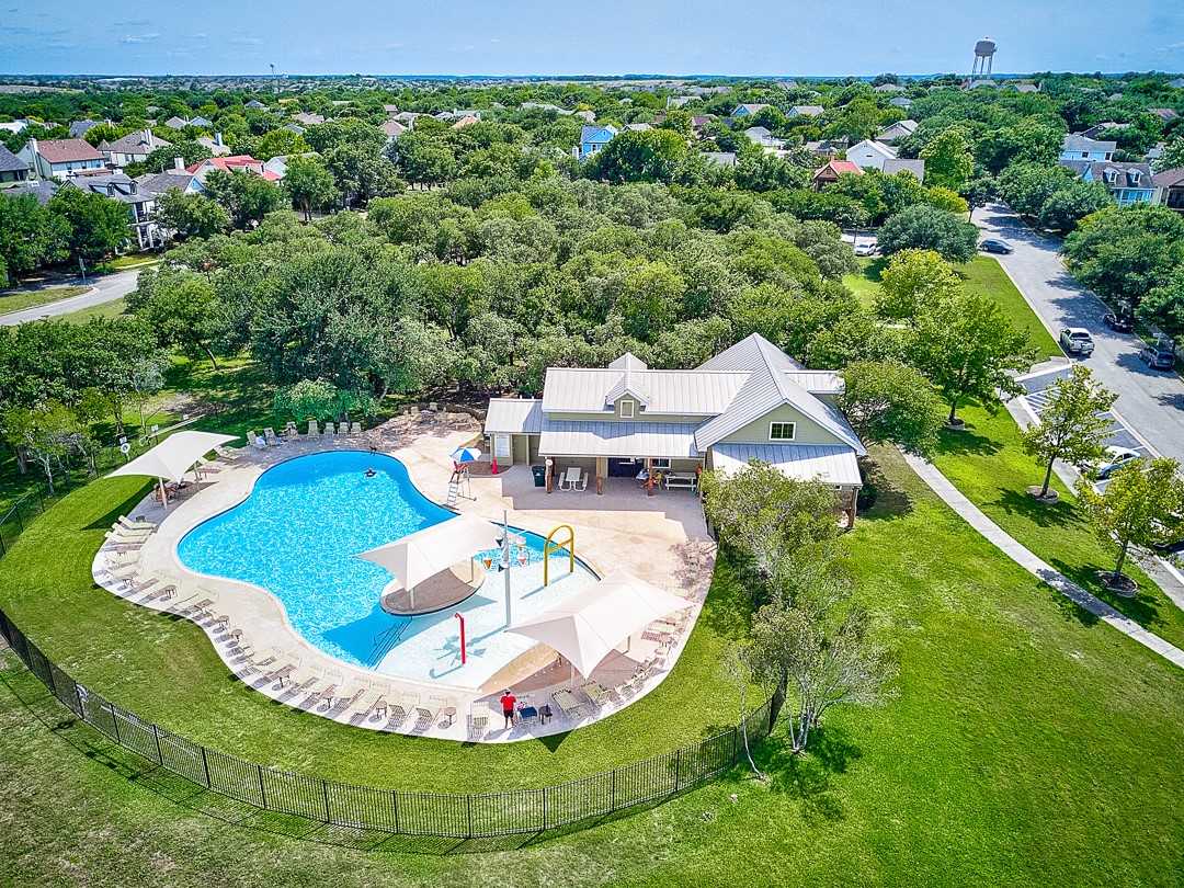 311 A Utterback Kyle, TX 78640 - Photo 38 of 40 Resort-style pool area featuring a freeform swimming pool, shaded lounging areas, and a shallow water play structure