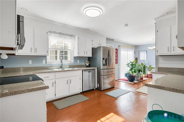 a kitchen with stainless steel appliances granite countertop a refrigerator sink and stove