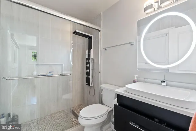 a bathroom with a sink a toilet and a mirror